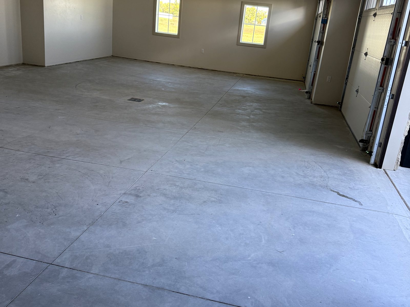 Before: large bare-concrete Reiles Acres, ND garage with blank white walls and no storage
