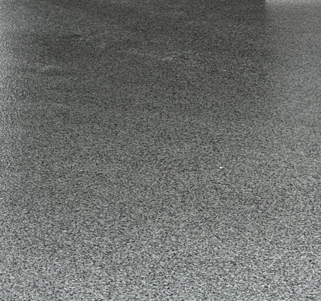 Close photo of a gray, black and white full-broadcast flake epoxy garage floor in Mapleton ND