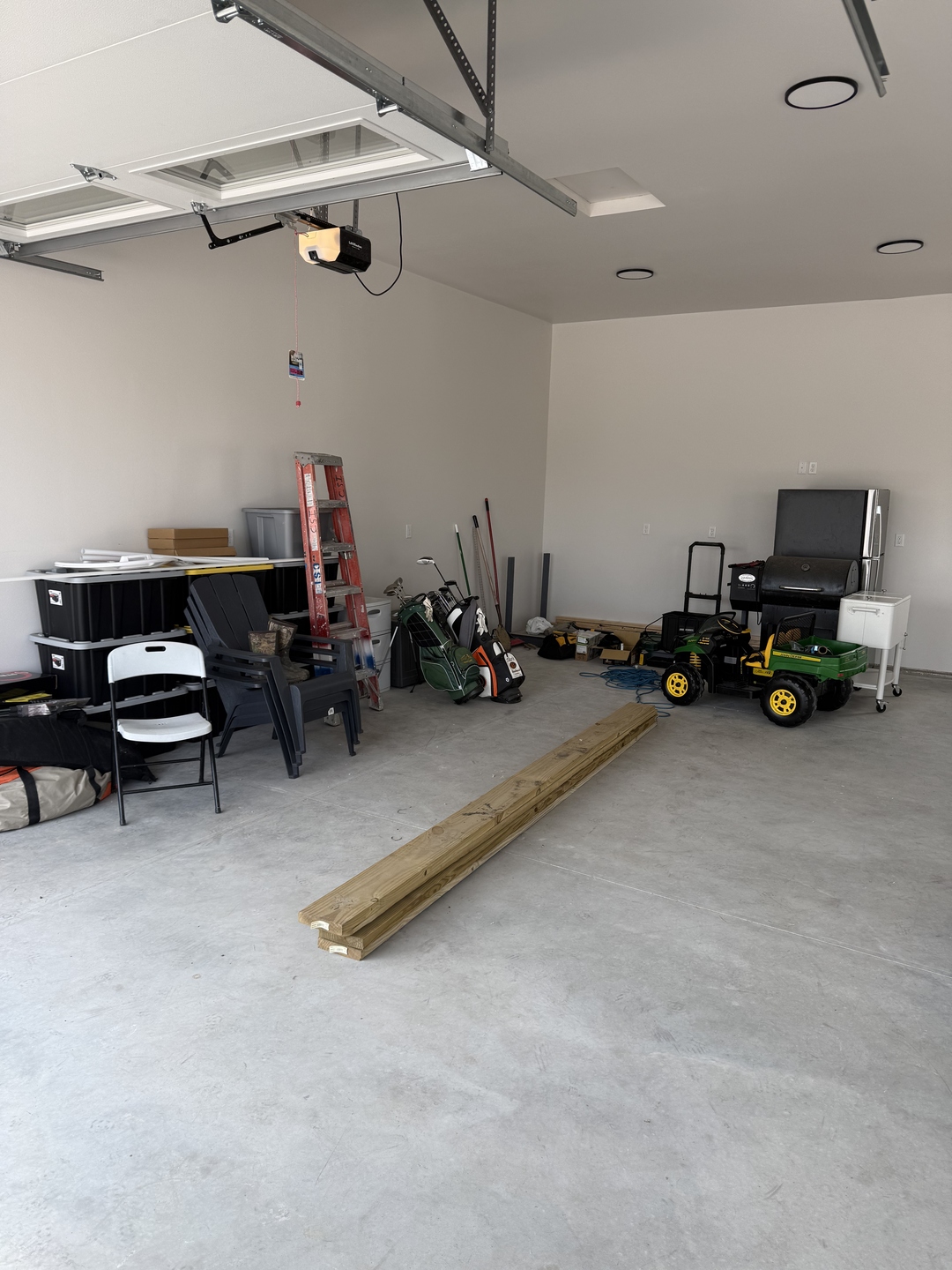Before photo of a Mapleton ND garage from the garage door with bare concrete and no garage cabinets, clutter along the wall