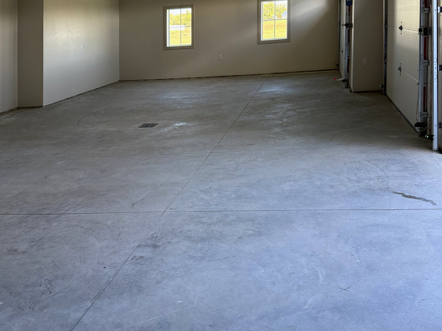 Before: the Reiles Acres, ND garage with bare gray concrete, control joints and blank white walls